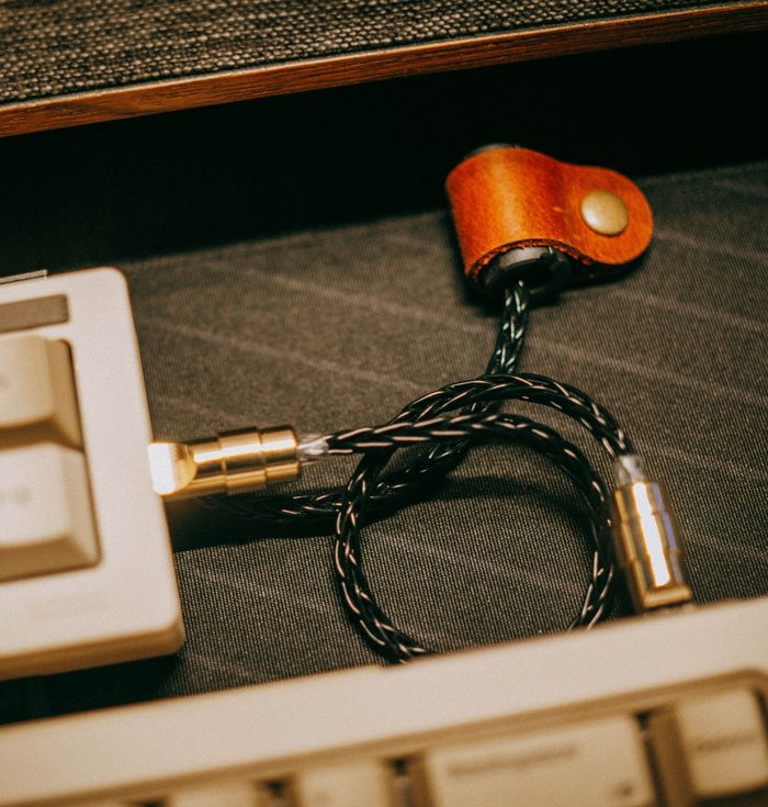 Tangentbord och flätad kabel på ett skrivbord – utvecklarens verktyg
