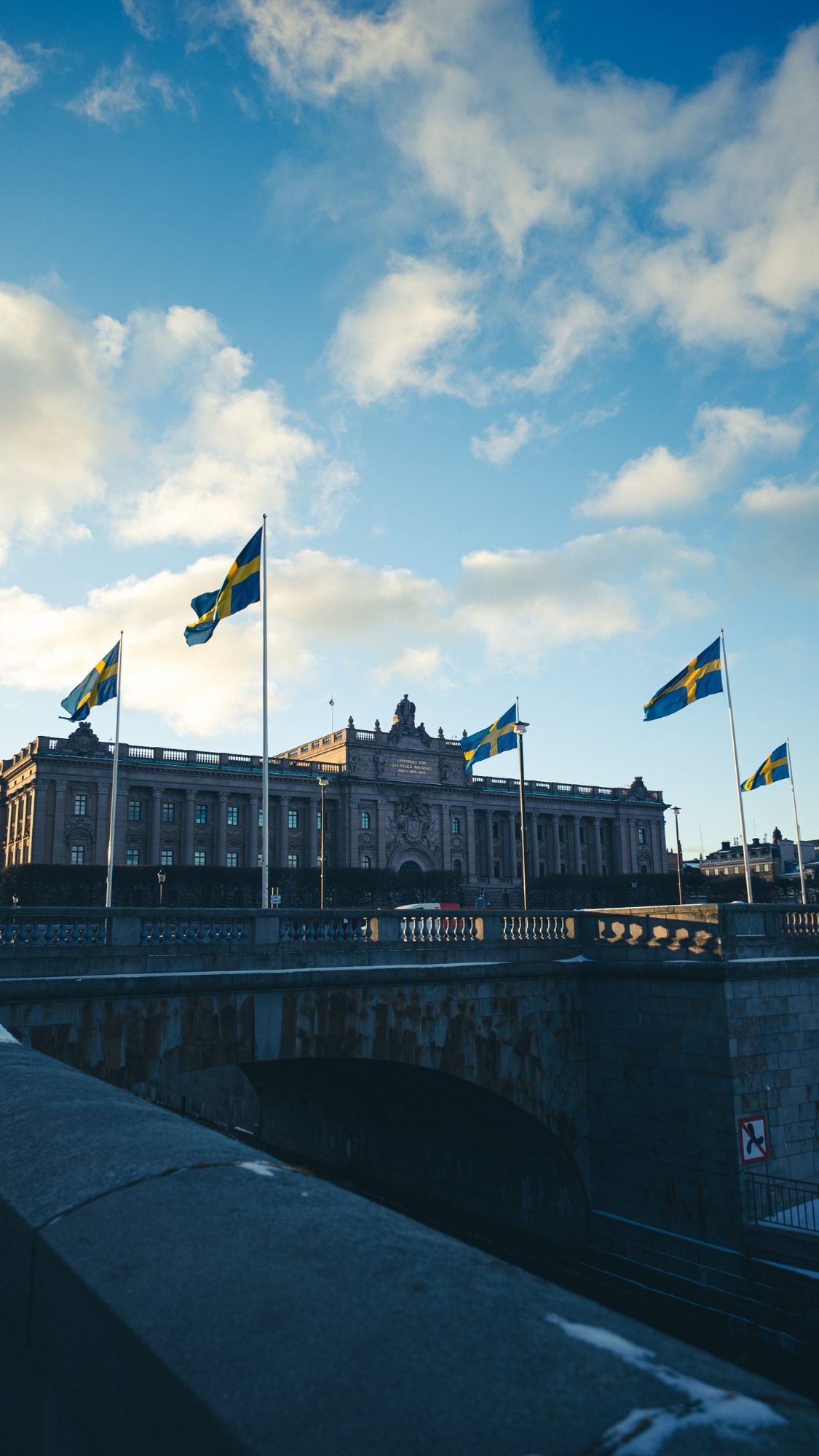 Riksdagshuset i Stockholm med svenska flaggor